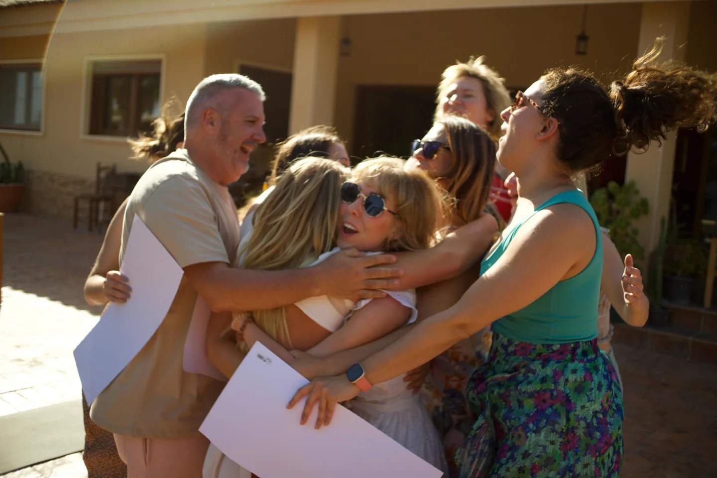 A joyful group gathering in a close embrace outdoors